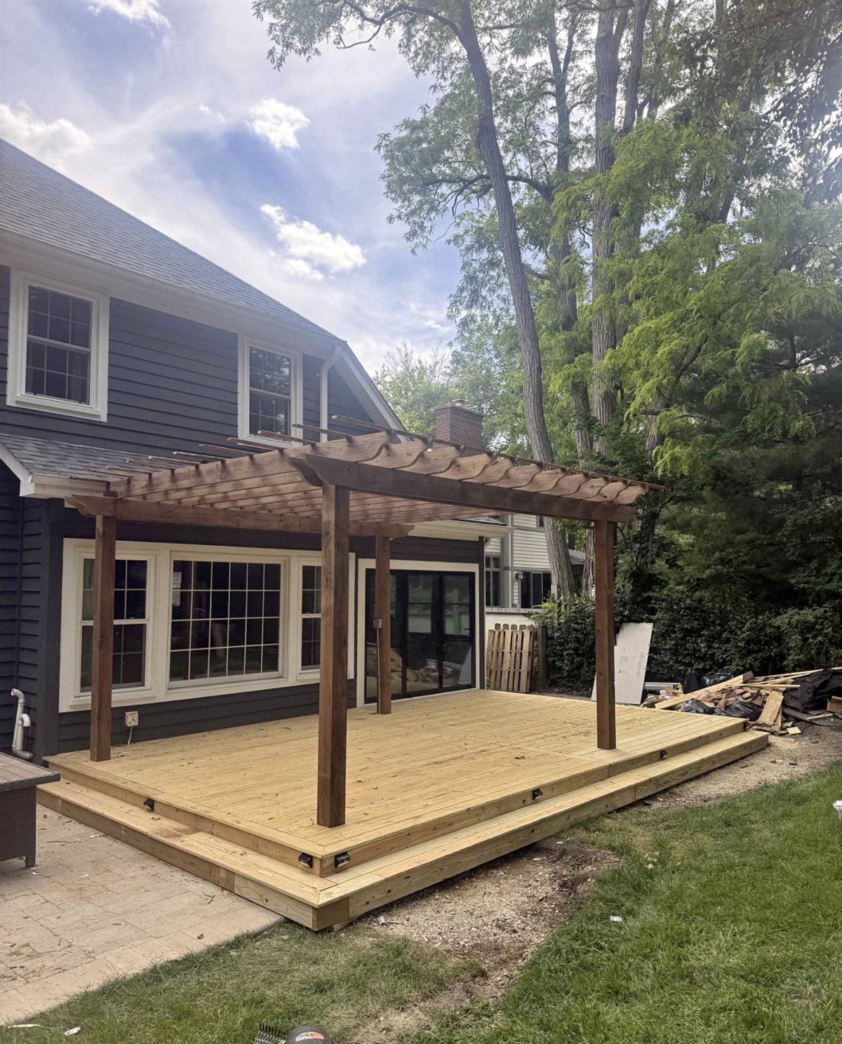 New cedar deck with a custom pergola behind a home